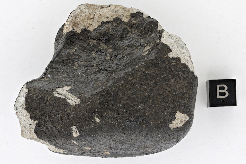 Gros plan sur la météorite "Tintigny". Le cube marqué d'un "B" donne l'échelle (1 cm). © Thierry Hubin/IRSNB